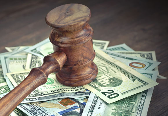 A judges gavel hits a pile of money