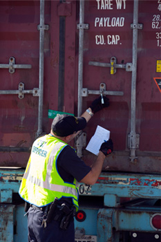 CBP officer inspects container with seal.