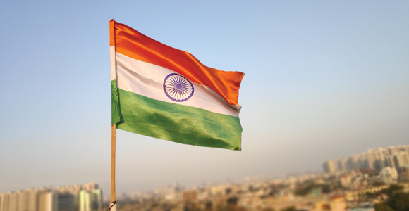 The India flag overlooking an Indian city.